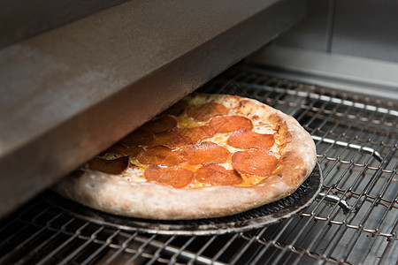 在烤箱里准备比萨饼烘烤午餐餐厅美食乡村披萨餐饮蔬菜火炉食谱图片