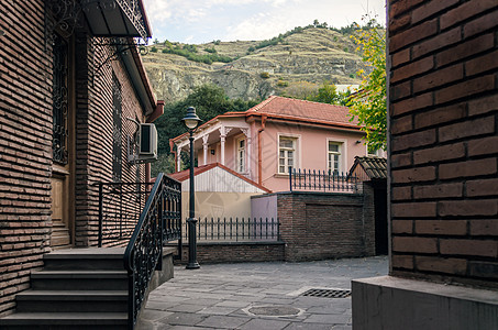 格鲁吉亚城市住宅和山上风景与树林图片