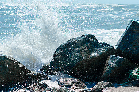 浴室海边海浪喷洒在黑石上 蜜蜂沙滩上蓝色石头冲浪海洋海水季节泡沫白色背景喷雾背景