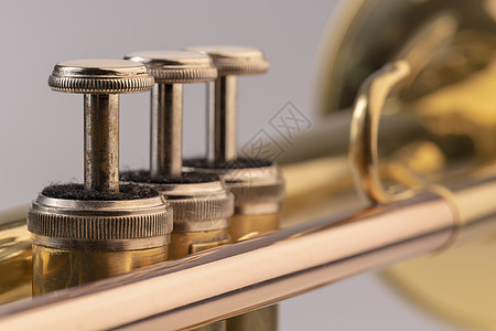 详细介绍音乐乐乐小号金属圆柱形照片黄铜按钮宏观损害古铜色生产阀门背景图片