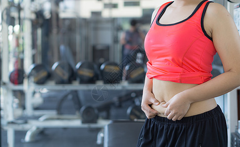 特写女人抱着过多的脂肪腹部 女人超重 abd手臂组织女性橘皮内衣身体运动健身房成人女士图片