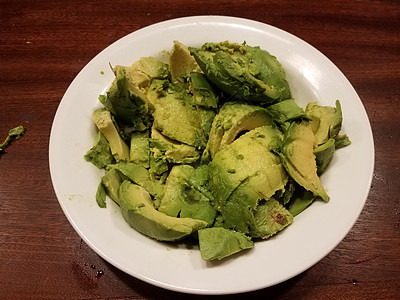 棕色木质桌上的绿鳄梨或瓜卡莫莱鳄梨木头小吃食物午餐桌子绿色白色背景图片