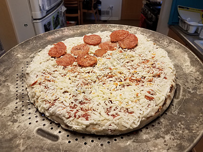 金属托盘上冷冻的奶酪和辣椒尼肉比萨小吃厨房食物午餐背景图片