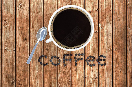 木制桌上的咖啡杯和咖啡豆图片