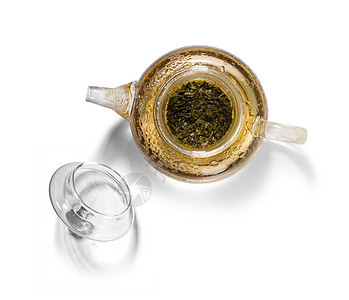 白底玻璃茶壶中的热绿色茶叶产品茶点杯子芳香早餐植物花瓣饮料液体仪式图片