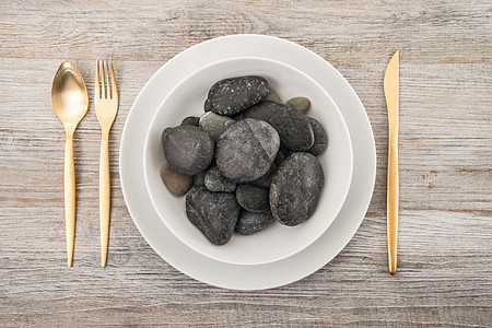 以木制的石头为盘子白色皮套菜单圆形食物饮食刀具木头概念岩石图片