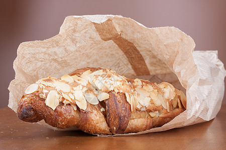 纸袋中鲜新鲜美味的金杏仁新月早餐食物白色美食面包黄油甜点脆皮小吃棕色图片