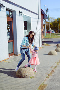 母亲和小女儿走着 玩着游乐游戏背景成人太阳孙女家庭童年吸引力女性玩具金发女郎图片