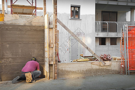 在建筑工地工作的工人武装房子劳动者工厂男人瓦工装修工程建造院子背景图片