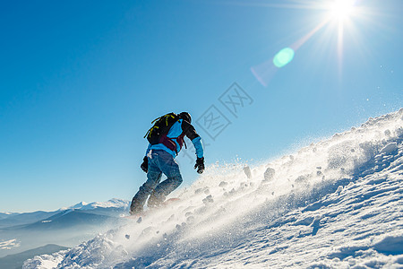 滑雪运动员在太阳尼日登上山峰的雪板 滑雪和冬季运动活动娱乐季节滑雪板背包蓝色粉末风镜旅行单板图片