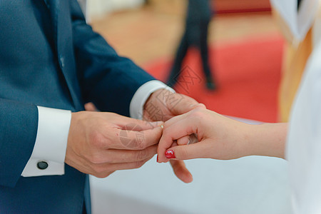 新娘和新郎在婚礼上把结婚戒指戴在手指上男性幸福夫妻庆典女士钻石婚姻仪式订婚生活图片