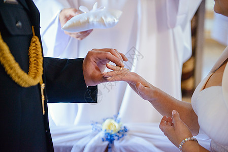 新娘和新郎在婚礼上把结婚戒指戴在手指上女士裙子订婚钻石家庭仪式夫妻幸福成人男性图片