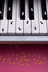 带纸笔的白色玩具钢琴白玩具 音乐钢琴概念乐器木头圆圈黑色旋律钥匙红色茶点食物商业图片