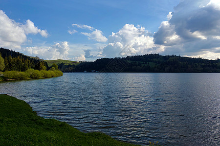 美丽的湖景 雨间明亮的间隔风景阳光旅行蓝色环境反射公园假期场景木头图片