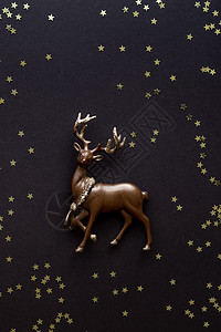深色背景上的微型鹿 闪亮的星星和复制空间 圣诞作文 明信片模板 平躺图片