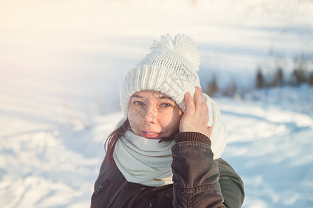 穿着白编织的帽子和雪下围巾的年轻欧洲快乐女性天气享受手套外套头发乐趣女士幸福毛衣微笑图片