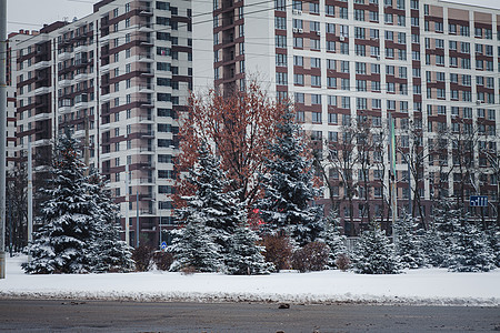 一辆汽车在下雪的冬季公路上沿着一座高楼行驶背光电视光束风暴运动暴风雪交通速度驾驶沥青图片