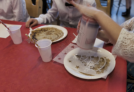 儿童们在桌边忙着用粉状的乌鸦煎饼背景图片