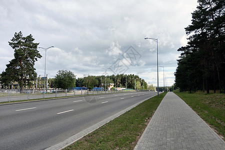 可以看到一条宽阔空旷的道路 路边有树木街道蓝色森林运输旅行公园交通太阳速度农村图片