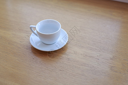 午后阳光下 一张木桌上放着一个没有饮料的纯白色陶瓷杯碟咖啡桌子咖啡店木头剪裁食物杯子盘子小路办公室图片
