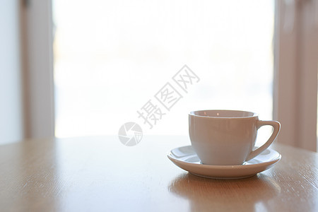 午后阳光下 一张木桌上放着一个没有饮料的纯白色陶瓷杯碟咖啡店食物办公室木头杯子桌子盘子小路咖啡早餐图片