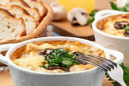 加鸡肉 蘑菇和奶酪的卡塞罗莱 在俄罗斯被称为Julienne 白碗加草药食欲烘烤餐具美食蘑菇面包食物鱼片香菜午餐图片