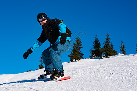 滑雪运动员在太阳尼日登上山峰红雪板 滑雪和冬季运动旅行行动娱乐单板男人木板活动天空头盔滑雪板图片