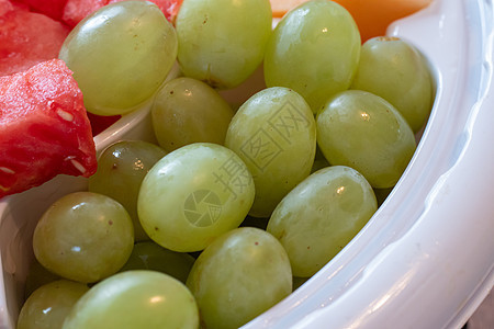 绿色葡萄在一个塑料水果盘里使用图片