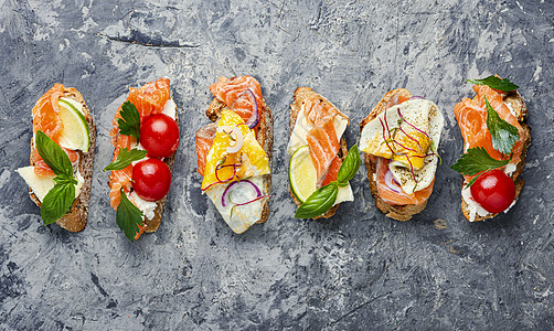 与鱼杂鱼混杂的布鲁沙塔盘子熏制面包餐厅黄瓜鳟鱼桌子草本植物蔬菜海鲜图片
