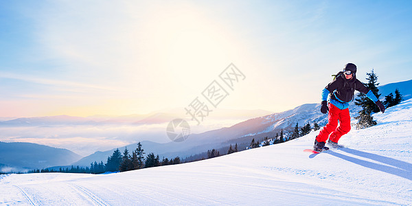 滑雪者骑着红雪雪板 在太阳天气清晨山的斜坡上 滑雪和冬季运动娱乐单板全景天空行动速度头盔滑雪板乐趣旅行图片