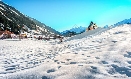 山地景观 冬季清晨全景教堂的雪脚足迹图画图片