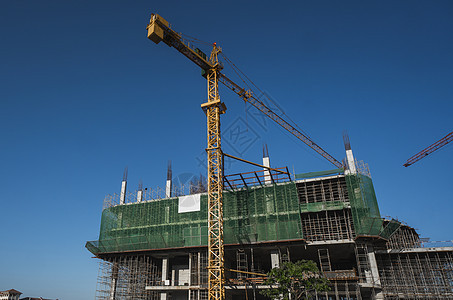 蓝天的起重机和建筑工地 未完工建筑的金属结构施工 塔式起重机用于建造多仓库建筑商业工程城市住宅住房生长天空脚手架工作高楼图片