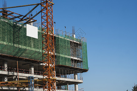 蓝天的起重机和建筑工地 未完工建筑的金属结构施工 塔式起重机用于建造多仓库建筑住宅公寓项目机器蓝色商业脚手架工作技术生长图片