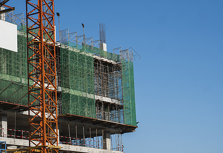 蓝天的起重机和建筑工地 未完工建筑的金属结构施工 塔式起重机用于建造多仓库建筑生长高楼机器天空蓝色城市工程住宅住房房子图片