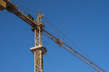 在建造多层储存建筑物或另一种结构的建筑工地上 在蓝天对着高塔起重机框架蓝色技术商业机器机械公寓天空手臂建筑学图片