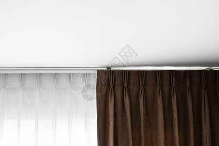 棕色窗帘和白色薄纱挂在栏杆上 白色天花板 客厅或卧室的窗帘室内装饰 舒适地住在自己的家里 甜蜜的家蓝色织物建筑学布料材料牛仔布控图片