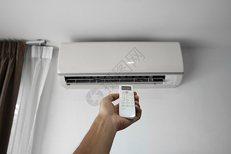 使用遥控器的人的手 手持 rc 和调节安装在白墙上的空调温度 室内舒适温度 健康理念和节能冷气机手臂技术护发素按钮活力状况冷却器图片