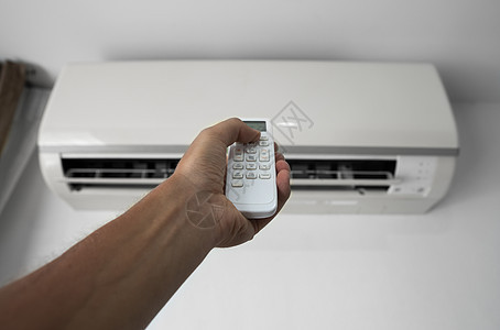 使用遥控器的人的手 手持 rc 和调节安装在白墙上的空调温度 室内舒适温度 健康理念和节能扇子技术手臂通风力量冷却器加湿器微风状图片