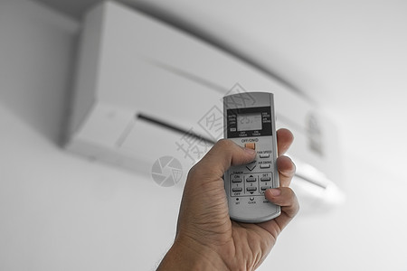 使用遥控器的人的手 手持 rc 和调节安装在白墙上的空调温度 室内舒适温度 健康理念和节能扇子活力状况净化器技术通风冷气机办公室图片