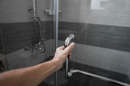 男性手在现代卫生间打开淋浴门跑步木头正方形卫生流动管道温泉房间酒店浴室图片