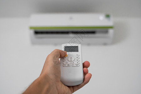 使用遥控器的人的手 手持 rc 和调节安装在白墙上的空调温度 室内舒适温度 健康理念和节能护发素活力冷气机扇子控制器具技术通风冷图片
