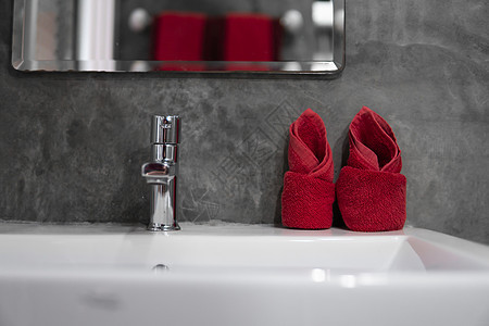 带洗脸盆水槽的现代不锈钢龙头 上面有两条红色毛巾 柜台浴室内部现代 豪华时尚的设计浴室配有混凝土风格的墙壁财产房子洗手间装饰镜子图片
