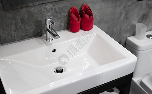带洗脸盆水槽的现代不锈钢龙头 上面有两条红色毛巾 柜台浴室内部现代 豪华时尚的设计浴室配有混凝土风格的墙壁陶瓷合金盆地家具房间镜图片