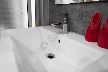 带洗脸盆水槽的现代不锈钢龙头 上面有两条红色毛巾 柜台浴室内部现代 豪华时尚的设计浴室配有混凝土风格的墙壁合金房间公寓洗澡金属房图片