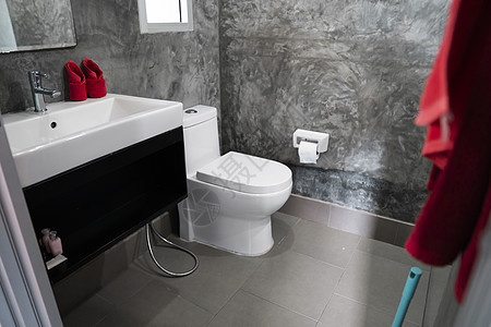 家用浴室的白色厕所 墙上挂着一个水槽和红色毛巾 有混凝土灰色瓷砖 墙上贴有卫生纸奢华组织卫生间房子平底锅家庭座位制品隐私房间图片