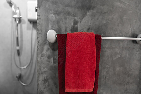 洗手间有一条红毛巾在烘干机上 反卫生间内部当代 豪华和时髦的设计浴室配有混凝土风格的墙壁肥皂奢华衣架酒吧治疗温泉化妆品家庭酒店按图片