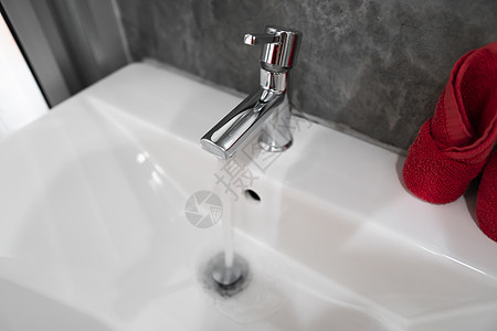 现代不锈钢水龙头的自来水在白色水槽中 与厕所内部当代相对立 奢侈和时髦的设计浴室配有混凝土风格的墙壁家具奢华财产卫生肥皂洗澡制品图片