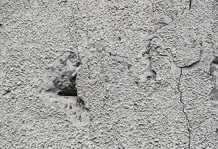 用灰色水泥纹理盖的破裂的混凝土灰色墙壁作为背景可以在设计中使用 有裂缝和孔洞的脏混凝土质地风化材料建筑学乡村建造建筑岩石地面石膏图片