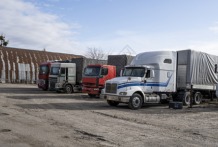 各种颜色和型号的现代卡车用于运输不同种类的商品 在卡车停靠站排成一排 等待工作航班的继续货车货物物流司机摩托车出租车交通发动机货图片