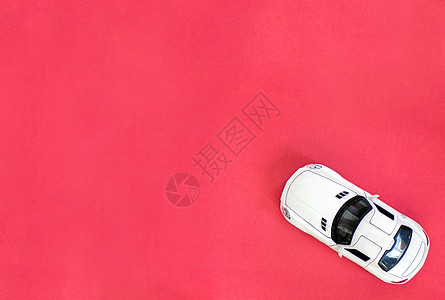 白色玩具车由红色背景的金属特制制造图片